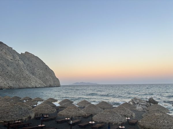 Perissa black sand beach at sunset with Mesa Vouno mountain in the background