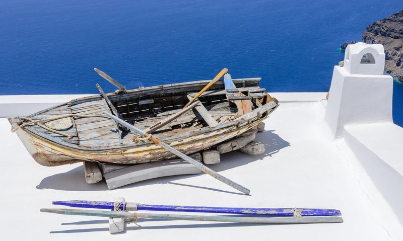 A rowing boat sits on the roof of a house in the village of Fira, Santorini, Greece.