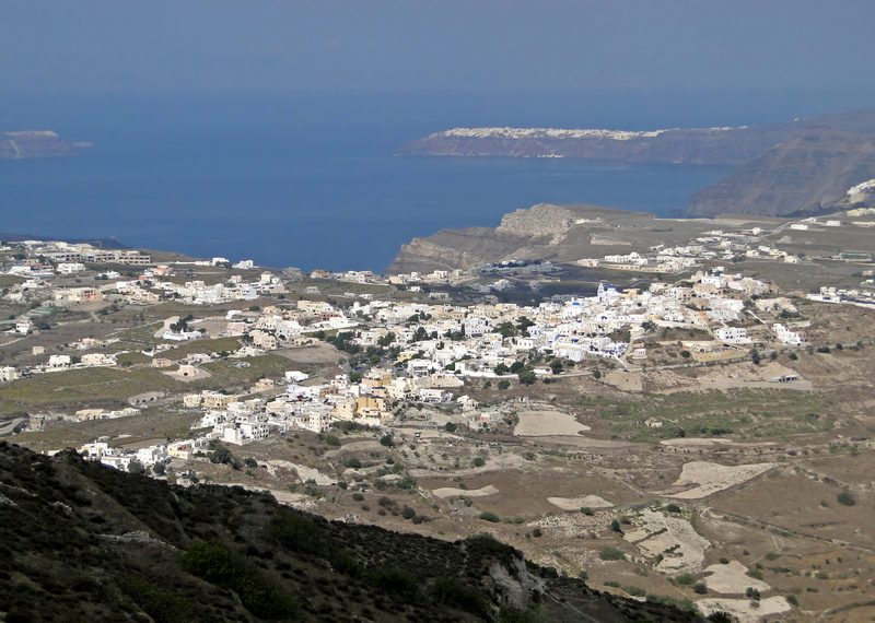 The hilltop village of Pyrgos viewed from above, with whitewashed buildings cascading down the slopes.