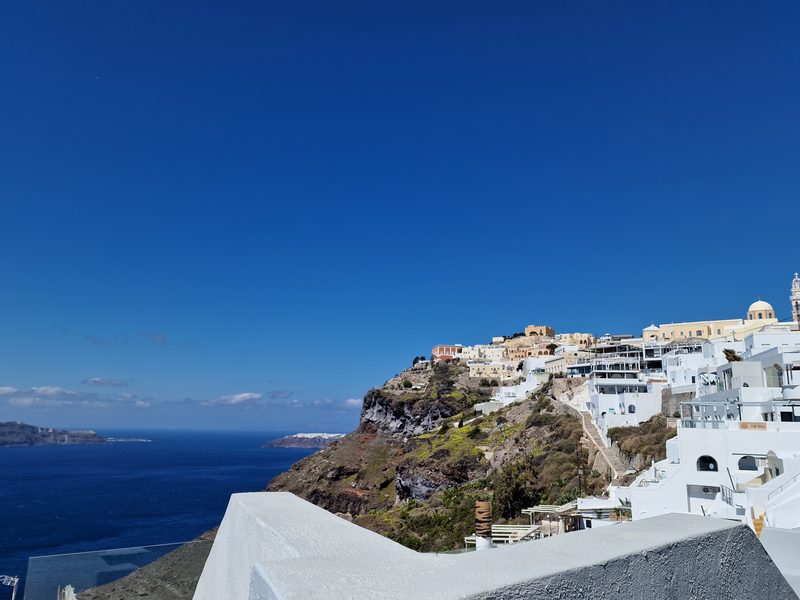 Whitewashed terraces cascade down the cliff at Imerovigli, with the caldera and Skaros Rock in the background