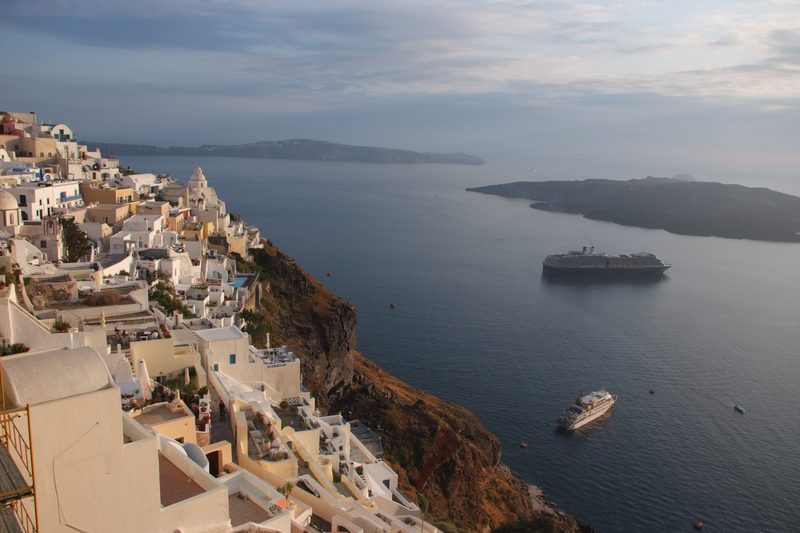 A vibrant sunset over the iconic cliffs of Santorini, Greece.