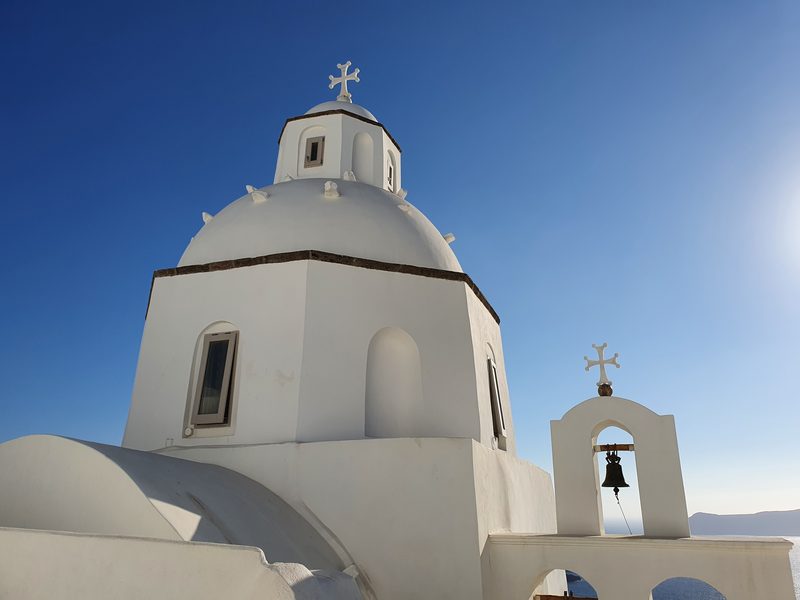 A whitewashed church dome and bell tower typical of the caldera-side villages along the hike
