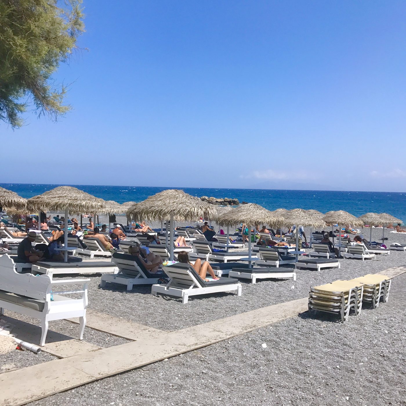 Kamari's black sand beach with clear turquoise water, Santorini