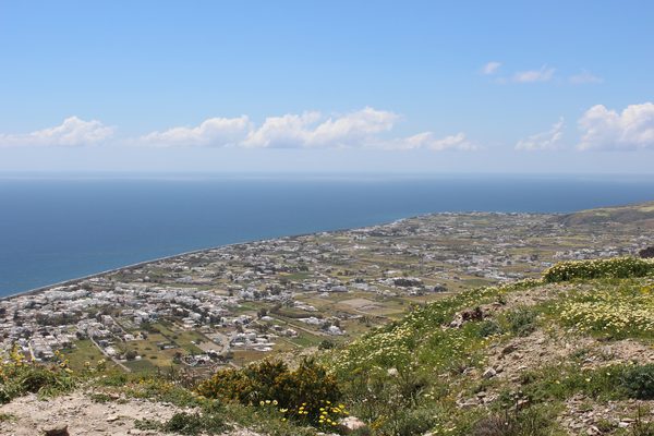The long stretch of Perivolos beach with dark volcanic sand, Santorini