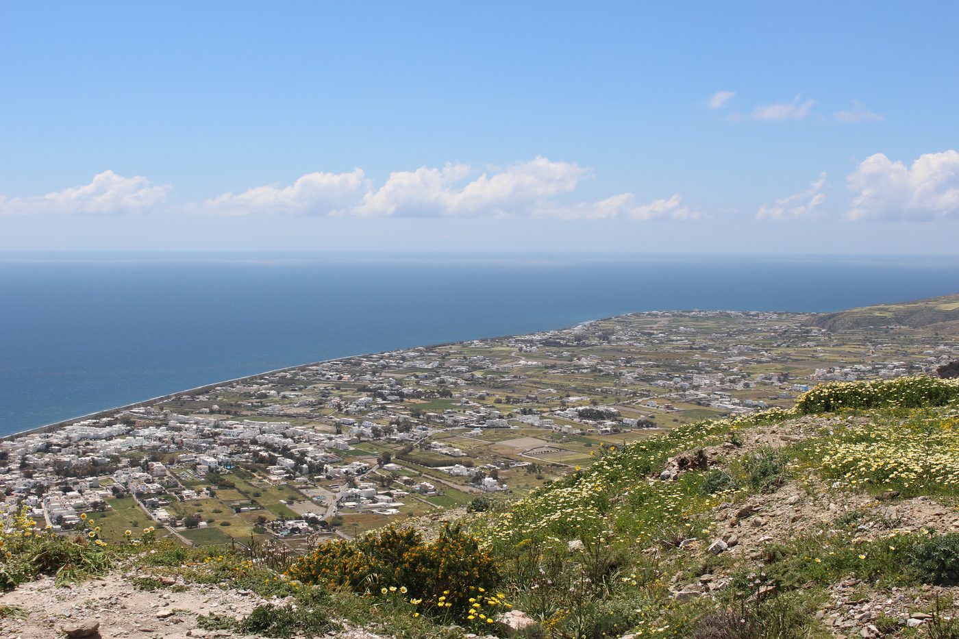 The long stretch of Perivolos beach with dark volcanic sand, Santorini
