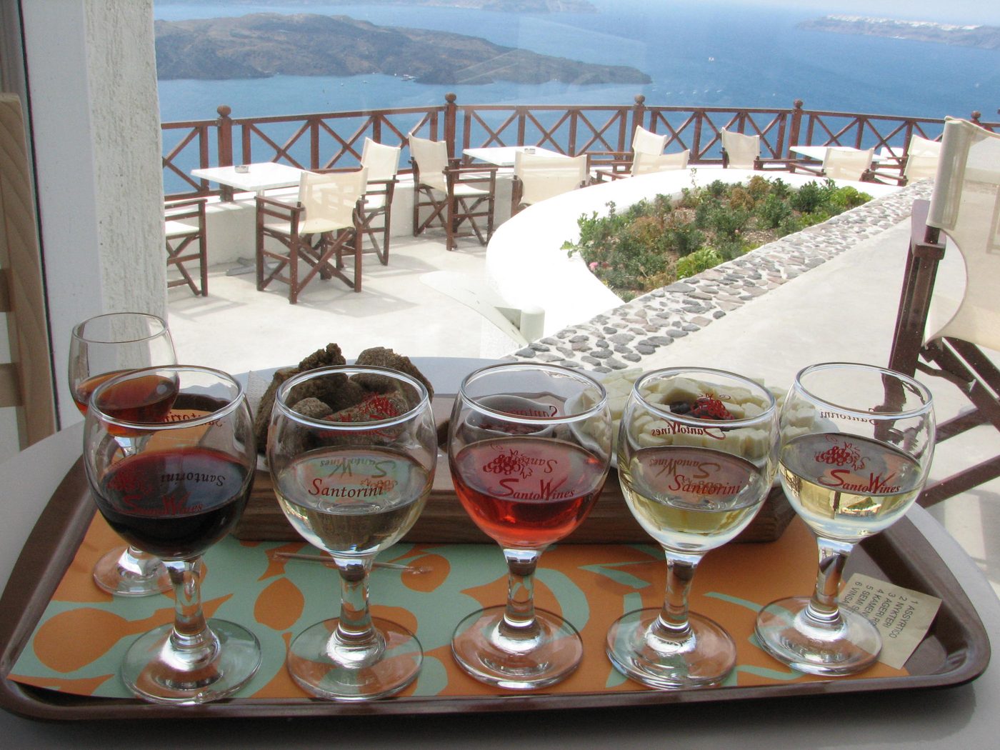 A bottle of Santorini wine surrounded by local wine production