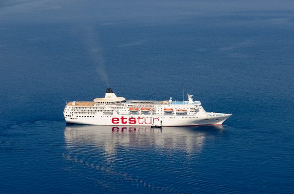 A cruise ship in the Santorini caldera with the volcanic cliffs behind