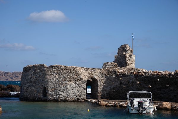 The Venetian castle of Naoussa with boats in the still harbour, Paros, Greece
