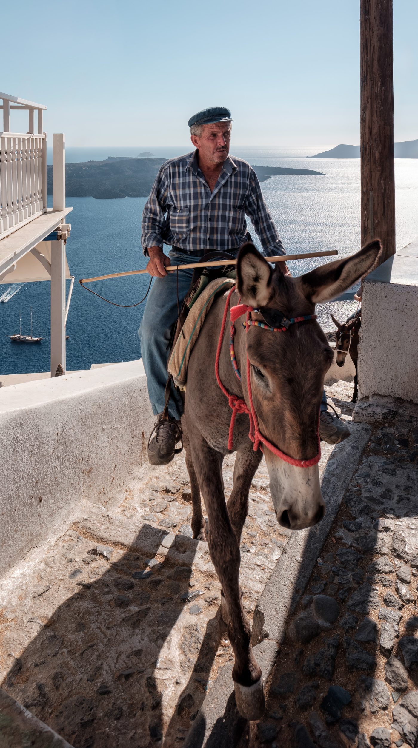 A donkey and rider navigating the narrow stairs of Fira, Santorini