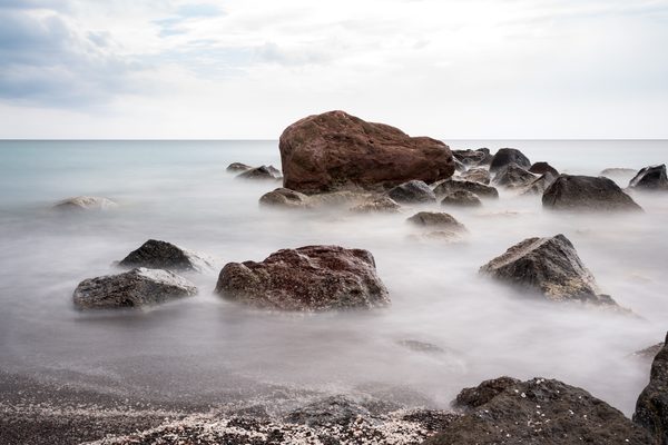 The dramatic white pumice cliffs and dark sand of Vlychada beach, Santorini