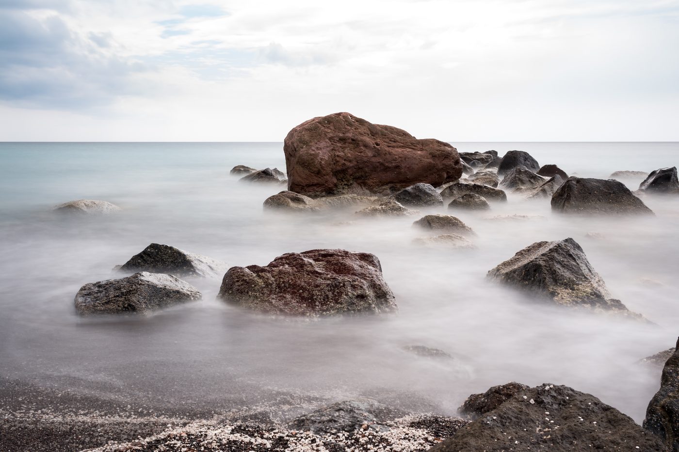The dramatic white pumice cliffs and dark sand of Vlychada beach, Santorini